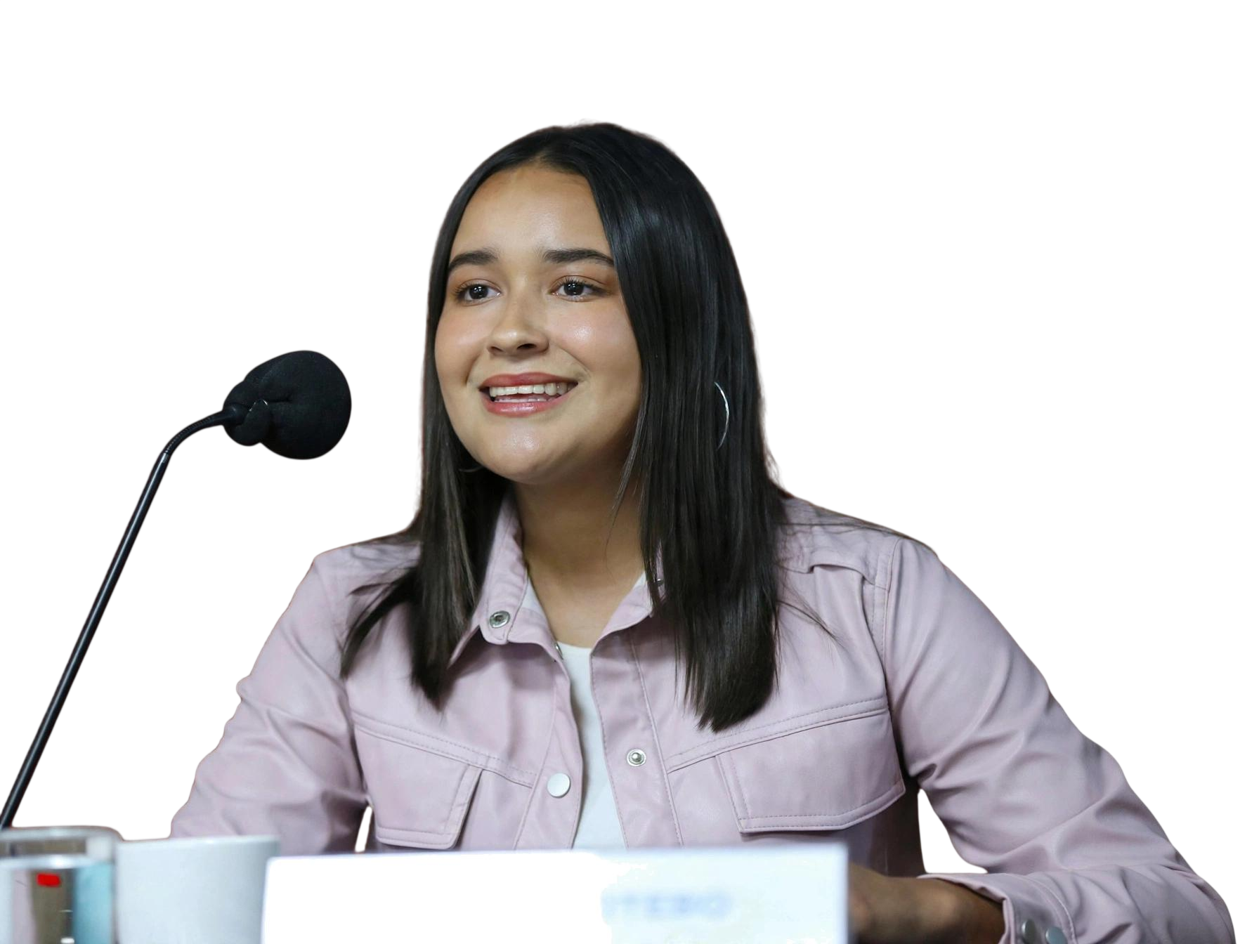 Gretel Cotero sonríe mientras habla en un micrófono durante una presentación.